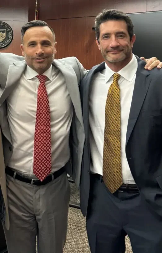 Two men in suits and ties posing for a picture.