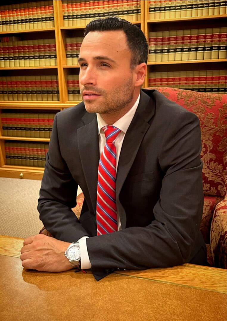 A man in suit and tie sitting at table.