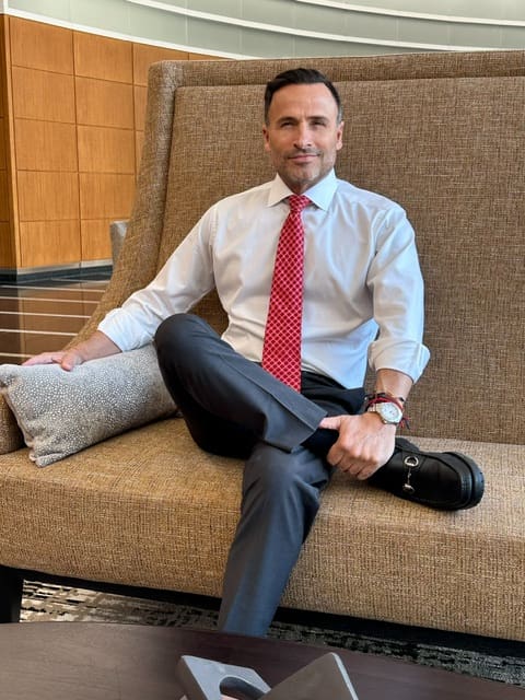 A man sitting on top of a couch wearing a tie.